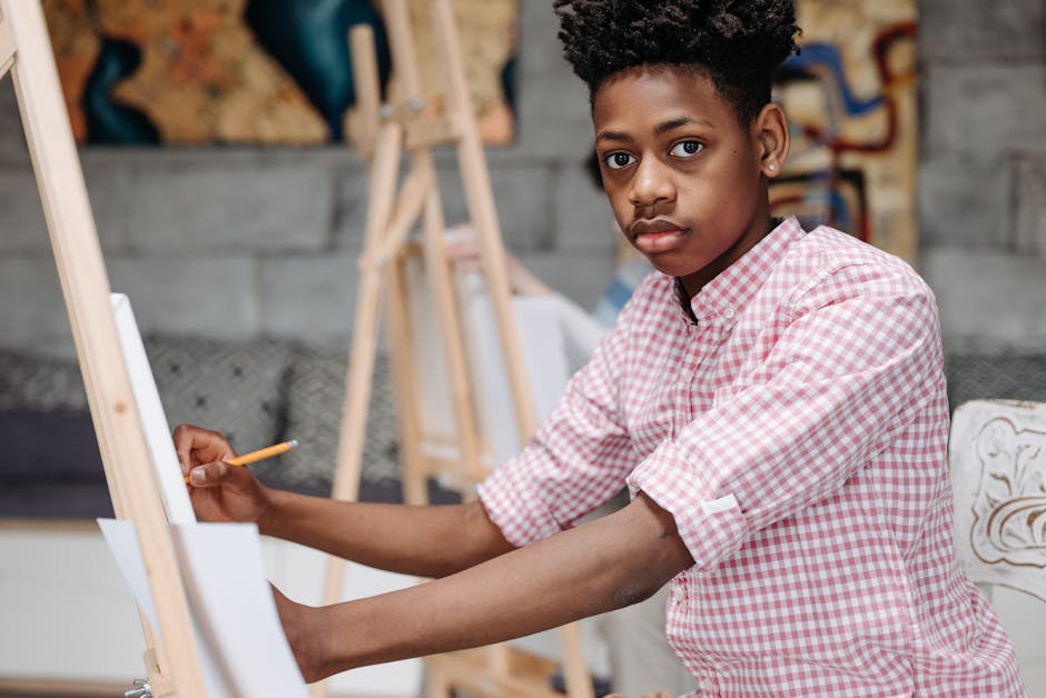 African American boy painting during art class, focused on creativity.